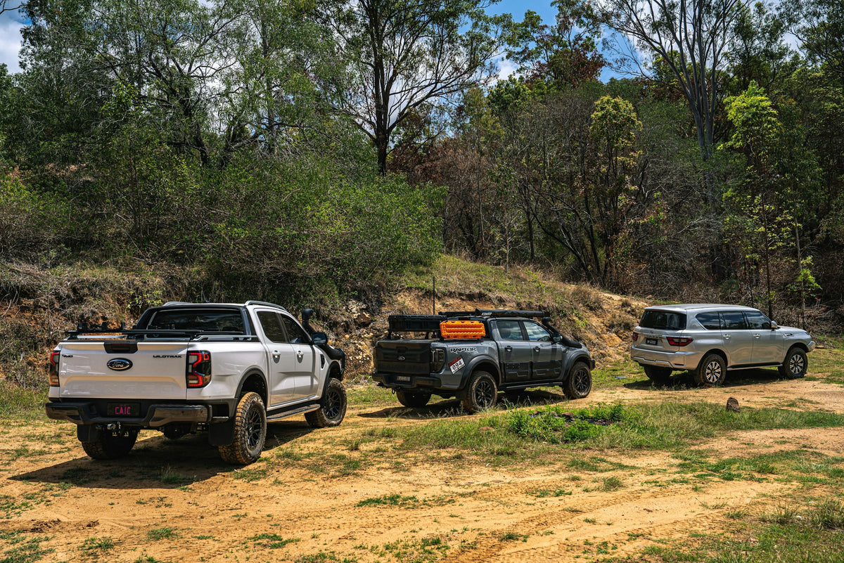 Three 4WDs stopped on a dirt track